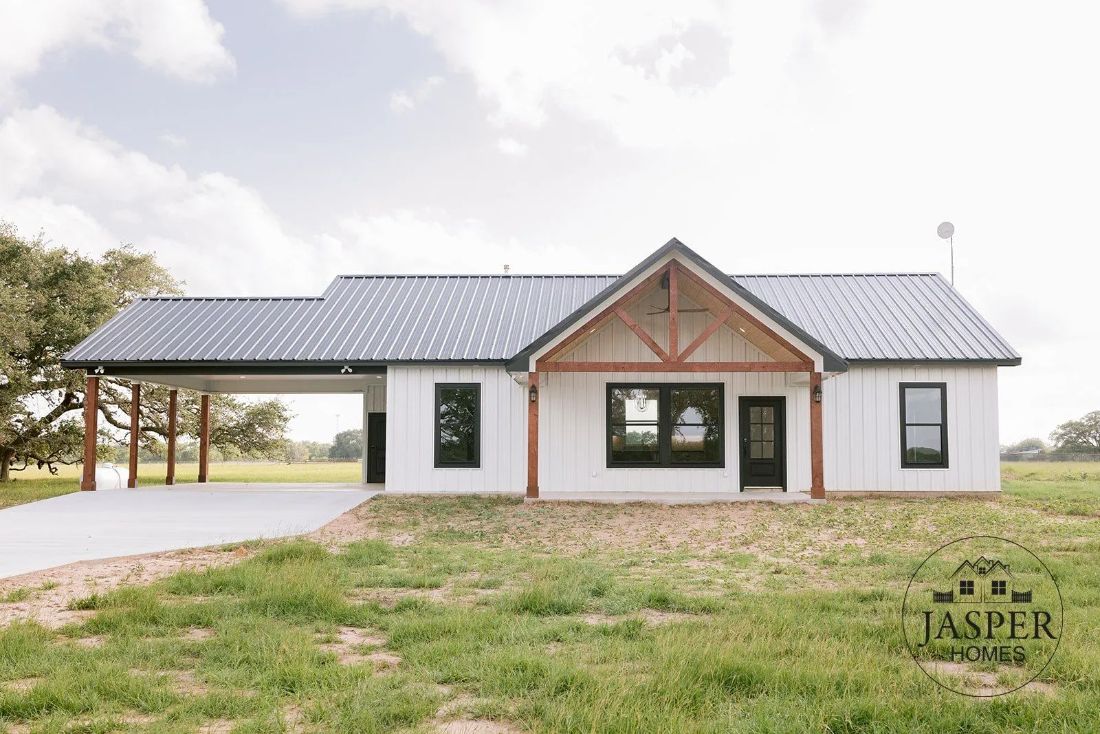 White barndominium with metal roof, cedar truss, and carport