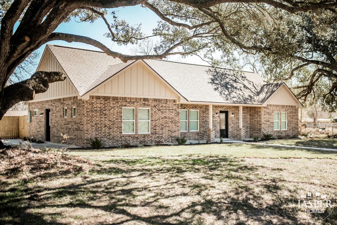 Brick ranch home shaded by live oak trees